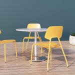 Yellow ARIES chairs with white Battery table on wood planks with planter in background