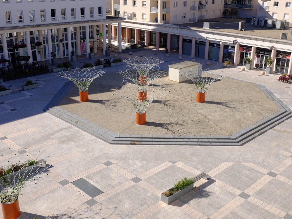 Urban Canopee Corolle's powdercoat orange standard planters on concrete in outdoor space